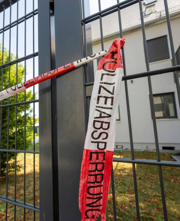 04.08.2026, Bayern, Augsburg: Vor einem Haus hat die Polizei eine Absperrung angebracht. Im Rahmen eines Polizeieinsatzes wurden am Montag dort zwei Leichen gefunden. Ein 29 Jahre alter Mann wurde festgenommen. Foto: Stefan Puchner/dpa +++ dpa-Bildfunk +++
