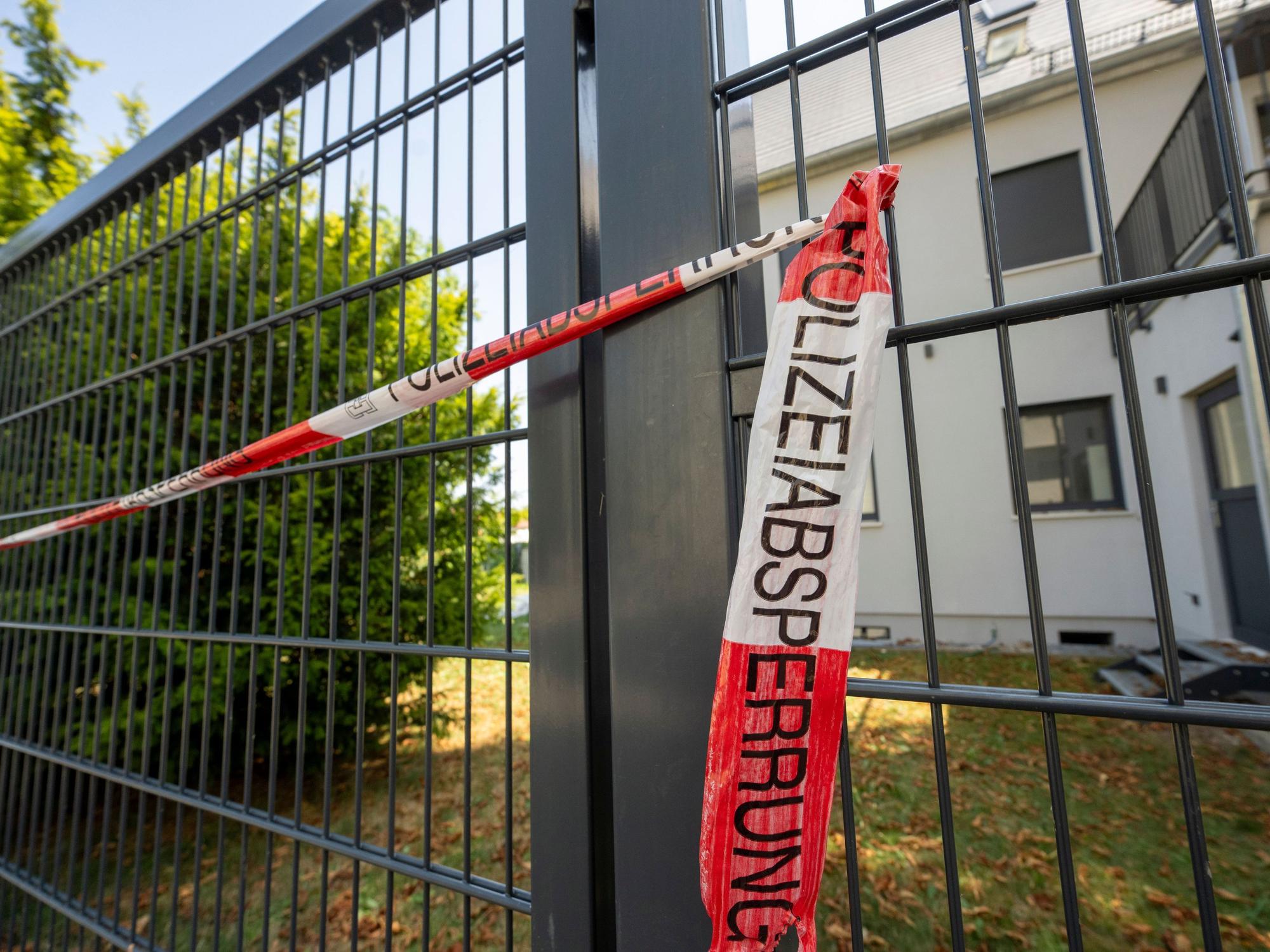 04.08.2026, Bayern, Augsburg: Vor einem Haus hat die Polizei eine Absperrung angebracht. Im Rahmen eines Polizeieinsatzes wurden am Montag dort zwei Leichen gefunden. Ein 29 Jahre alter Mann wurde festgenommen. Foto: Stefan Puchner/dpa +++ dpa-Bildfunk +++