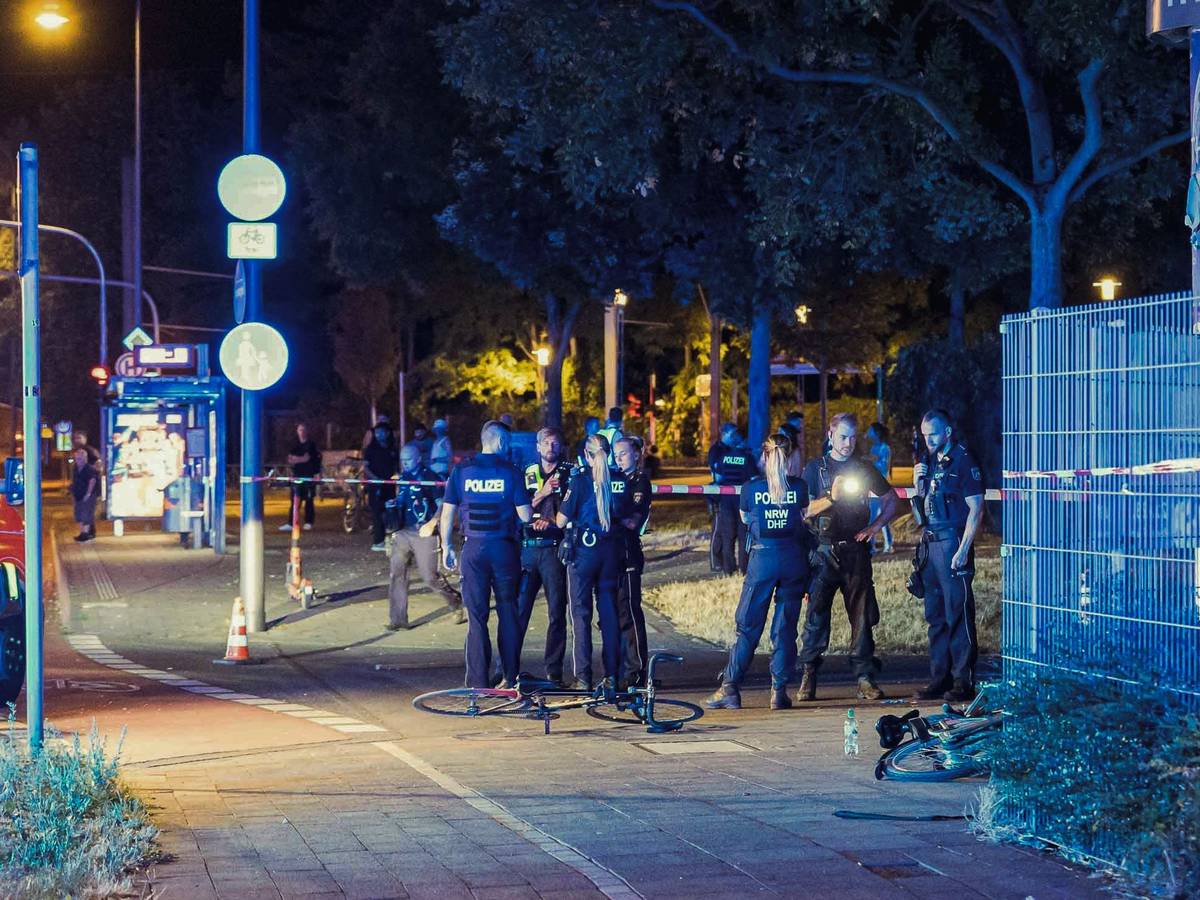 Die Polizei und Rettungskräfte sind in Köln Mülheim nach Schüssen auf offener Straße an einem Tatort beschäftigt.