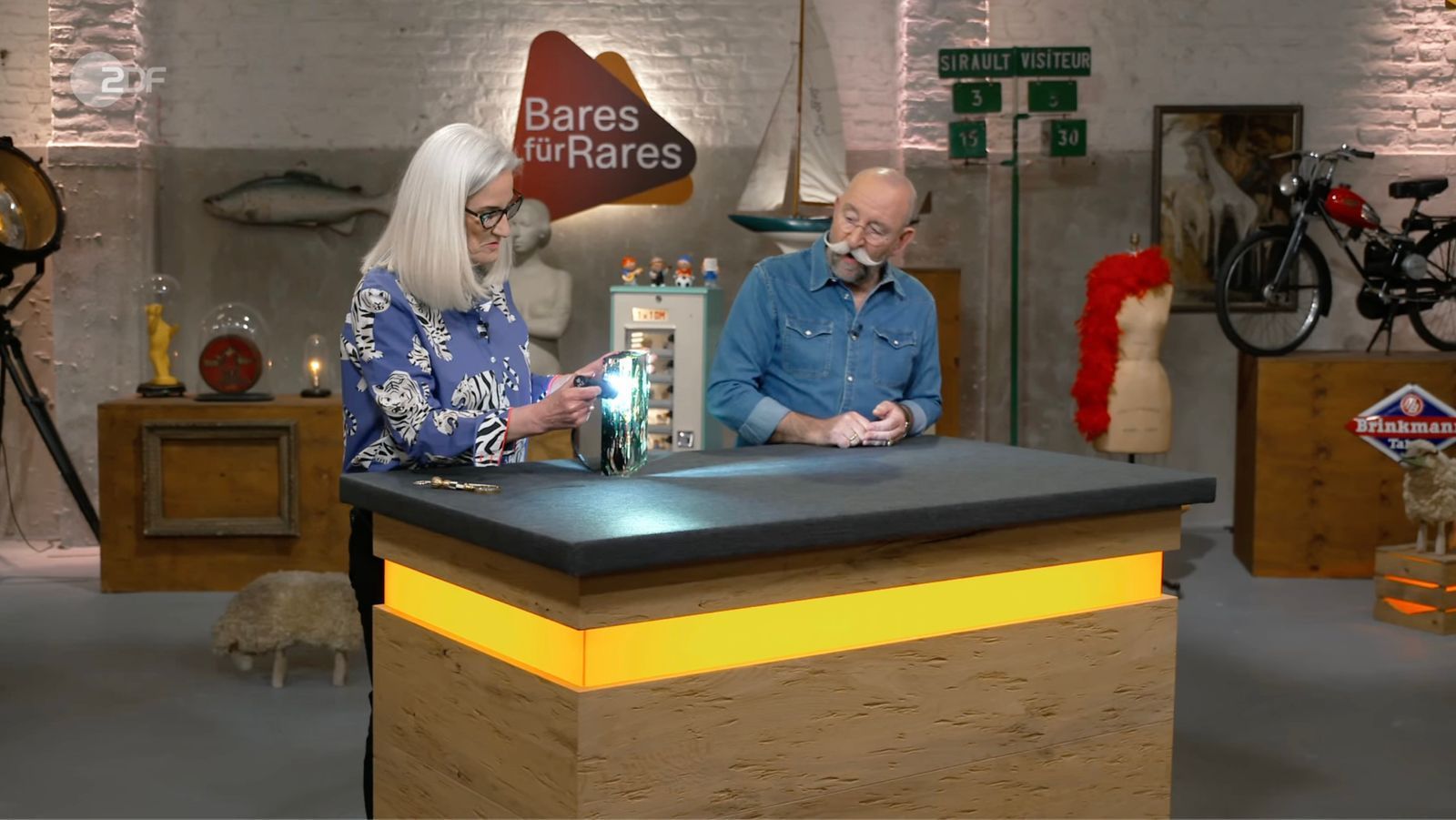 Horst Lichter war sofort begeistert, als in der Mittwochsausgabe von „Bares für Rares“ (ZDF) ein außergewöhnliches Murano-Aquarium auf dem Expertentisch landete und dank der Taschenlampe die Details sichtbar wurden: „Das ist absolut der Hammer. Wunderschön.“ Im Händlerraum begann die Auktion überraschend zögerlich - samt „frechen“ Geboten ... (Bild: ZDF)