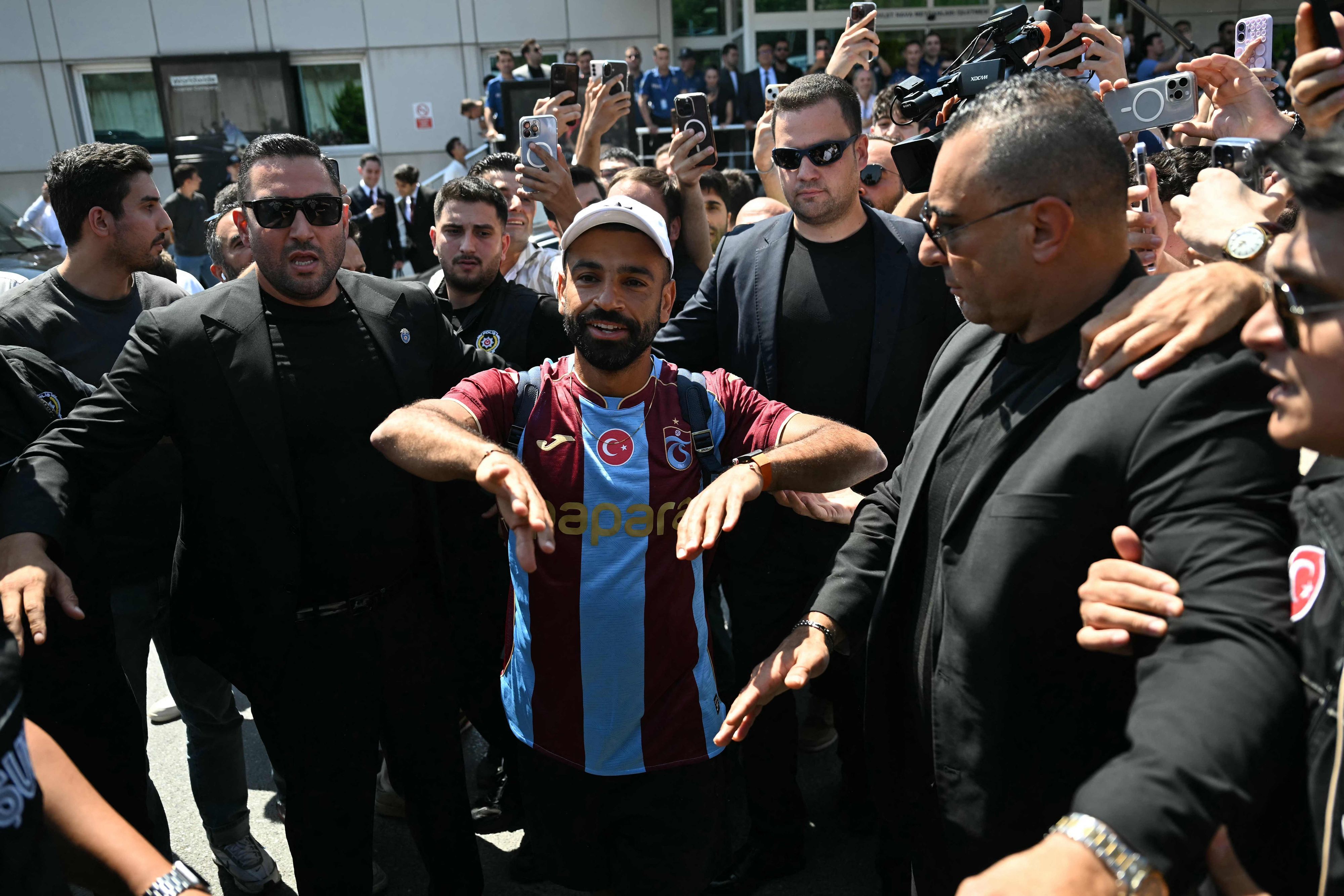Mohamed Salah agiert am Flughafen mit Fans.