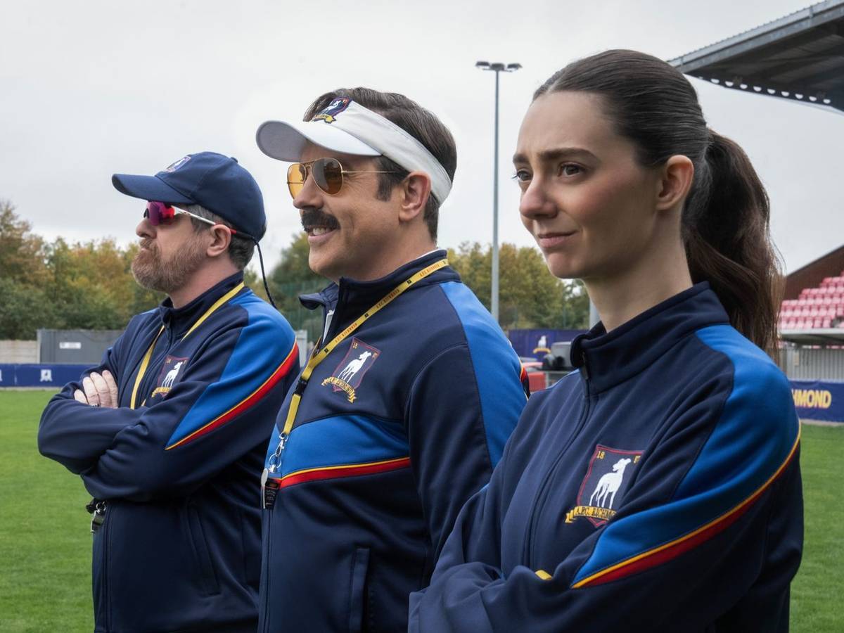 Mit Coach Beard (Brendan Hunt) und der schroffen Alice Chilton (Tanya Reynolds) hat Ted Lasso (Jason Sudeikis, Mitte) zwei hervorragende Co-Trainer an seiner Seite. (Bild: © Apple TV / Collin Hutton)