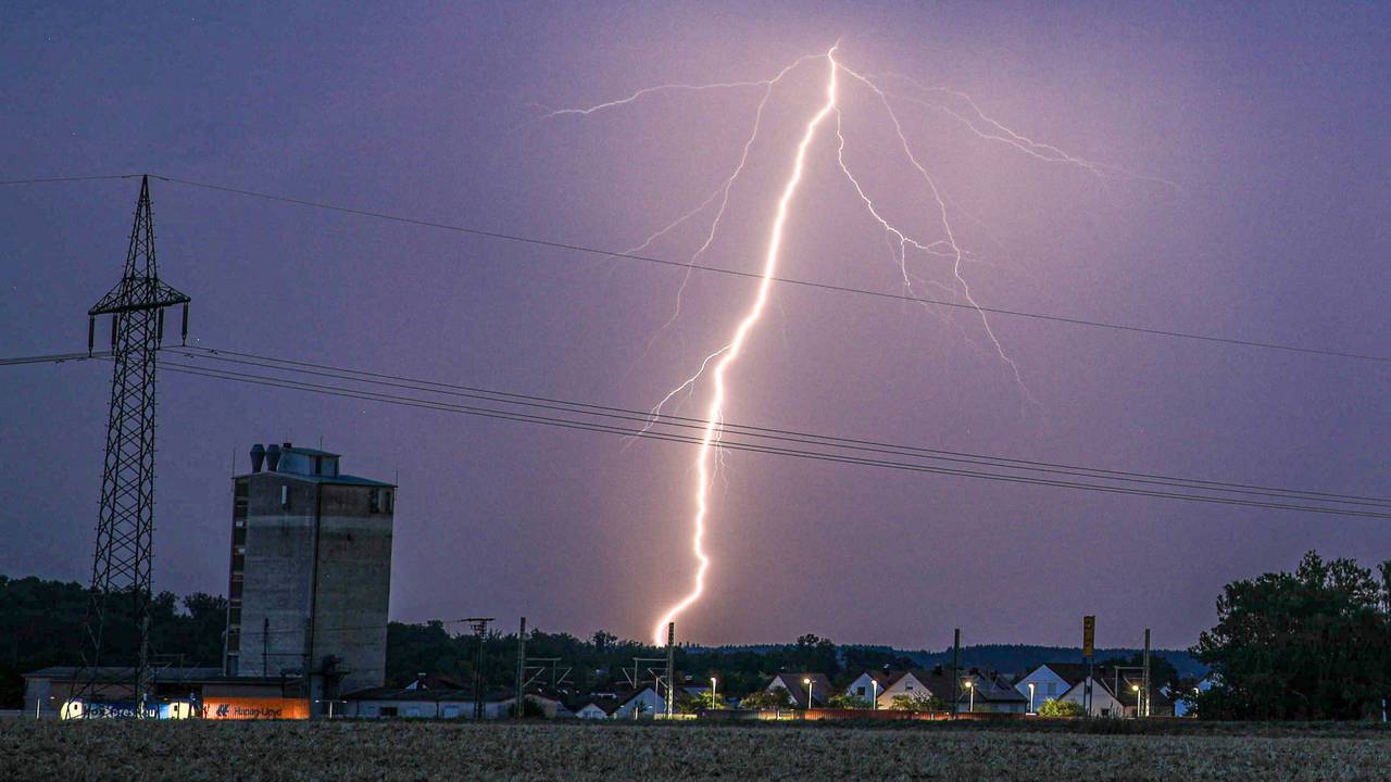 Ein Blitz erhellt bei einem abendlichen Sommergewitter den Himmel.