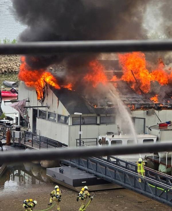 Das Dach des Sürther Bootshauses steht in Flammen.
