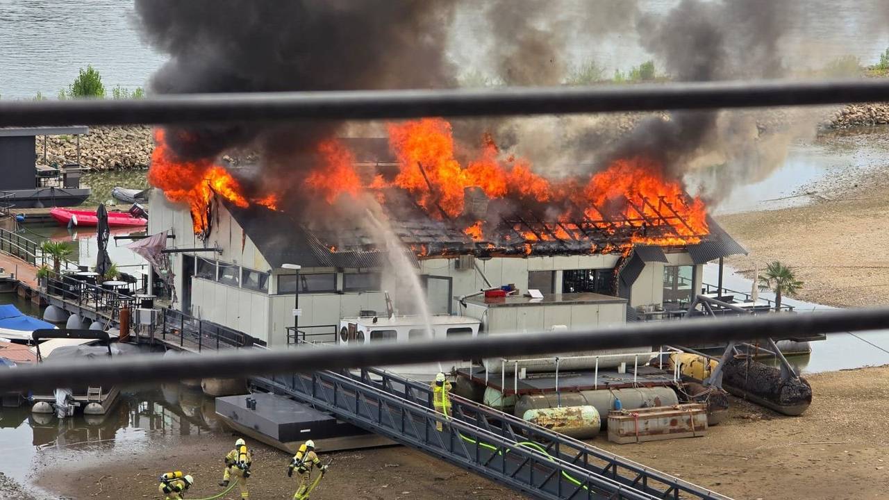Das Dach des Sürther Bootshauses steht in Flammen.