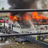Flammen schlagen aus dem Dach des Sürther Bootshauses.