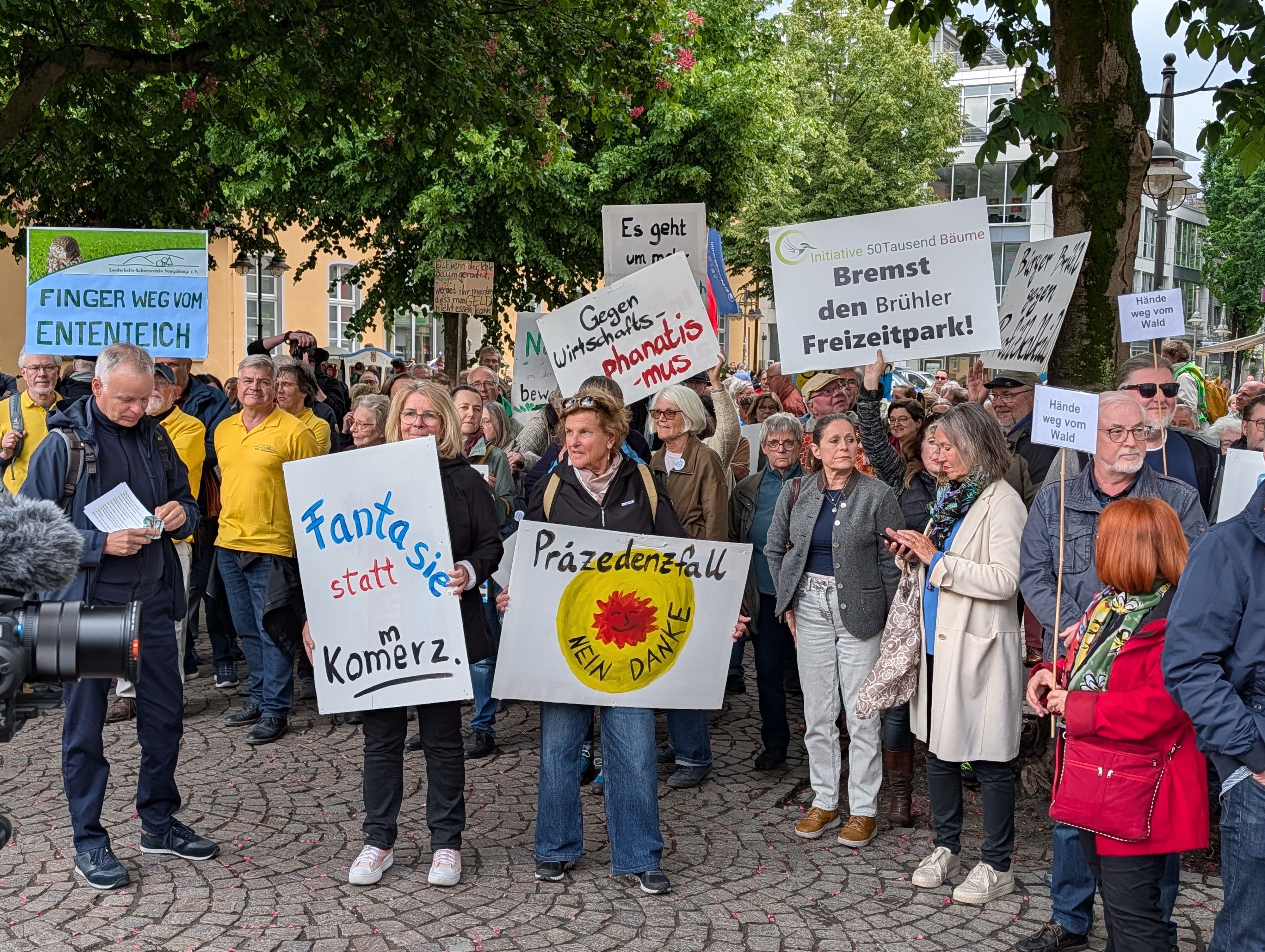 Menschen demonstrieren, halten Plakate hoch.