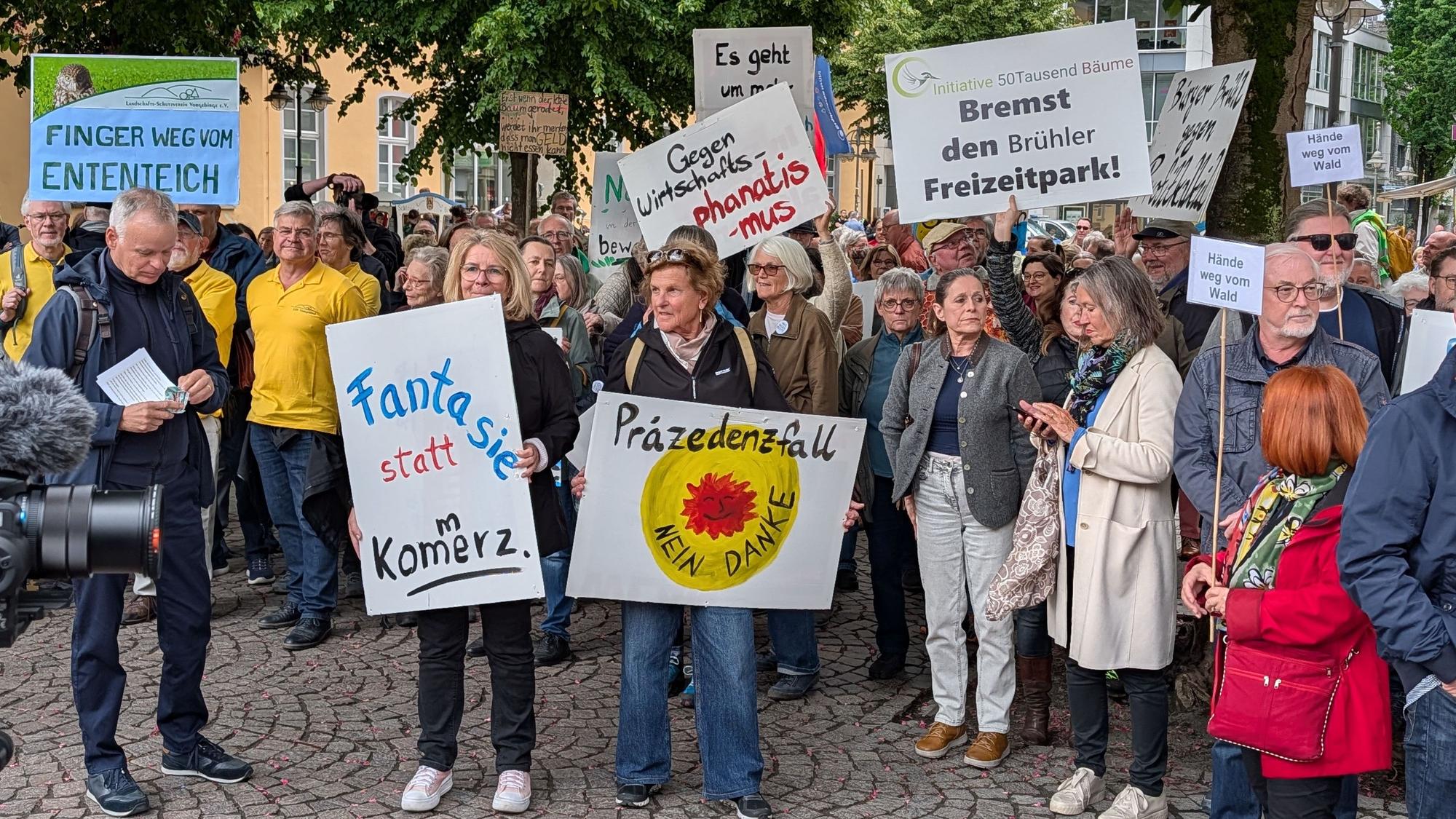 Menschen demonstrieren, halten Plakate hoch.