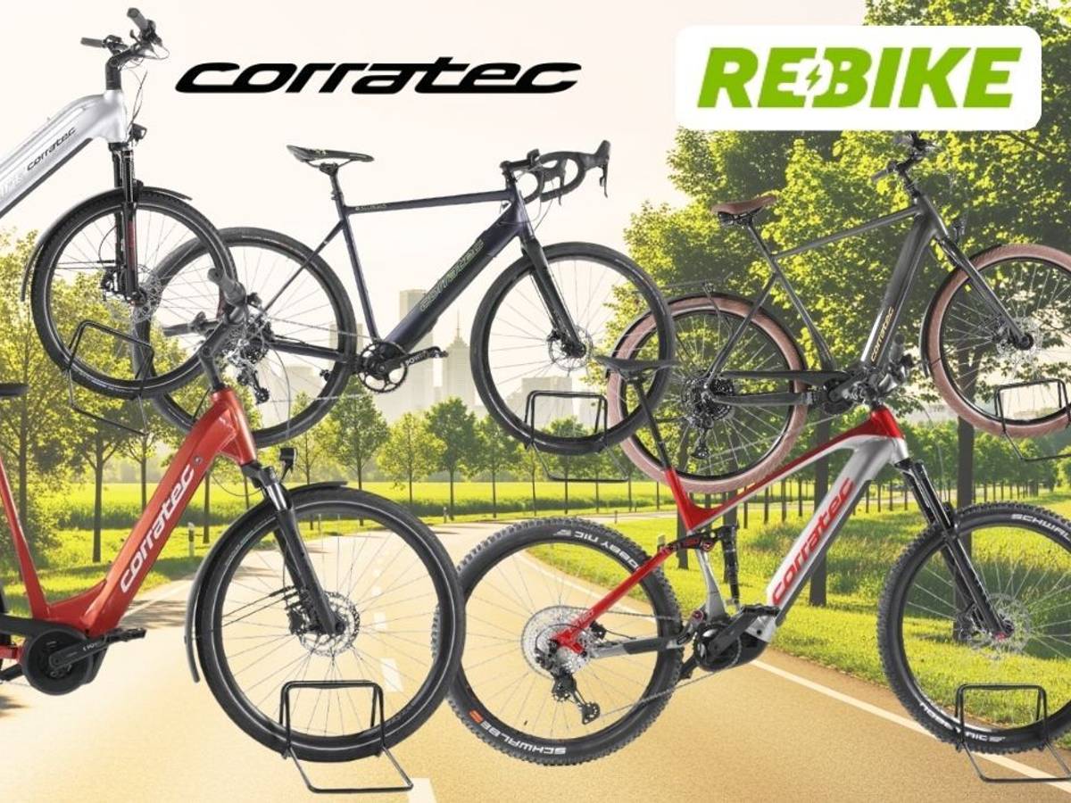 Mehrere Corratec E‑Bikes unterschiedlicher Typen – darunter Trekking-, City- und Mountainbikes – vor einer Landstraße an einem sonnigen Tag in Natur.