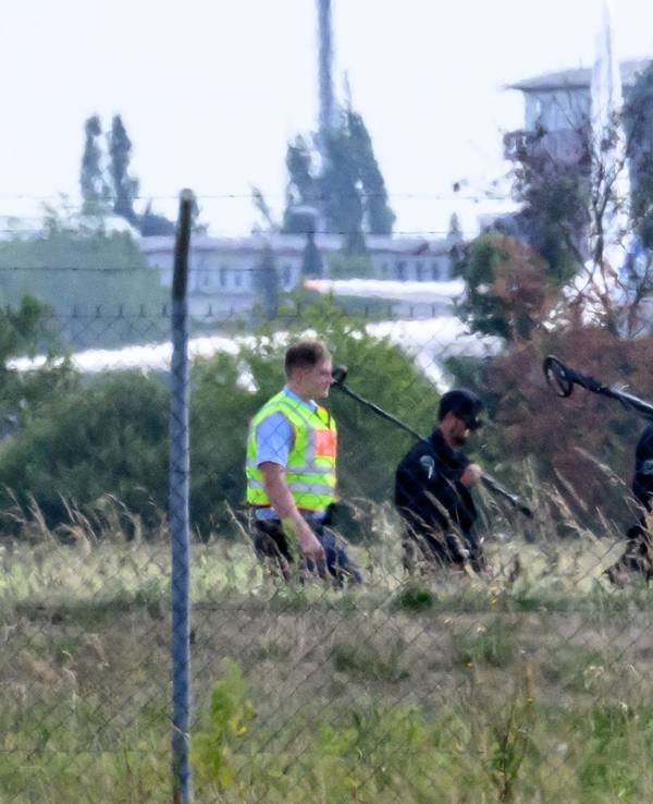 Einsatzkräfte der Polizei sind mit Metalldetektoren abseits der Landebahn Nord auf dem Gelände des Flughafens Leipzig/Halle unterwegs.