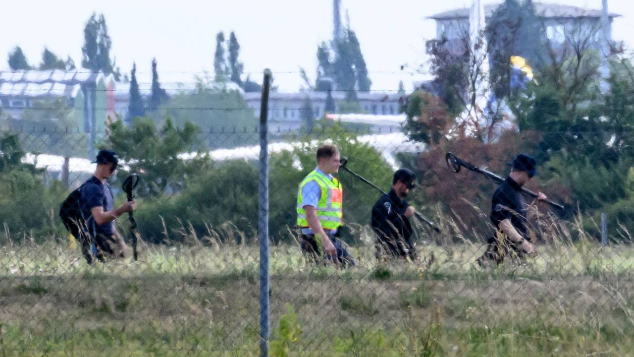 Einsatzkräfte der Polizei sind mit Metalldetektoren abseits der Landebahn Nord auf dem Gelände des Flughafens Leipzig/Halle unterwegs.