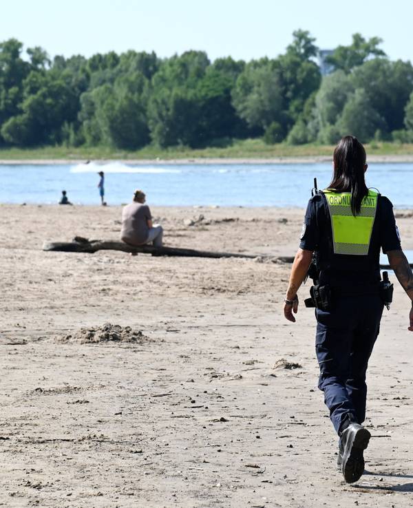 Das Ordnungsamt kontrolliert das Badeverbot im Rhein am Strand in Rodenkirchen.