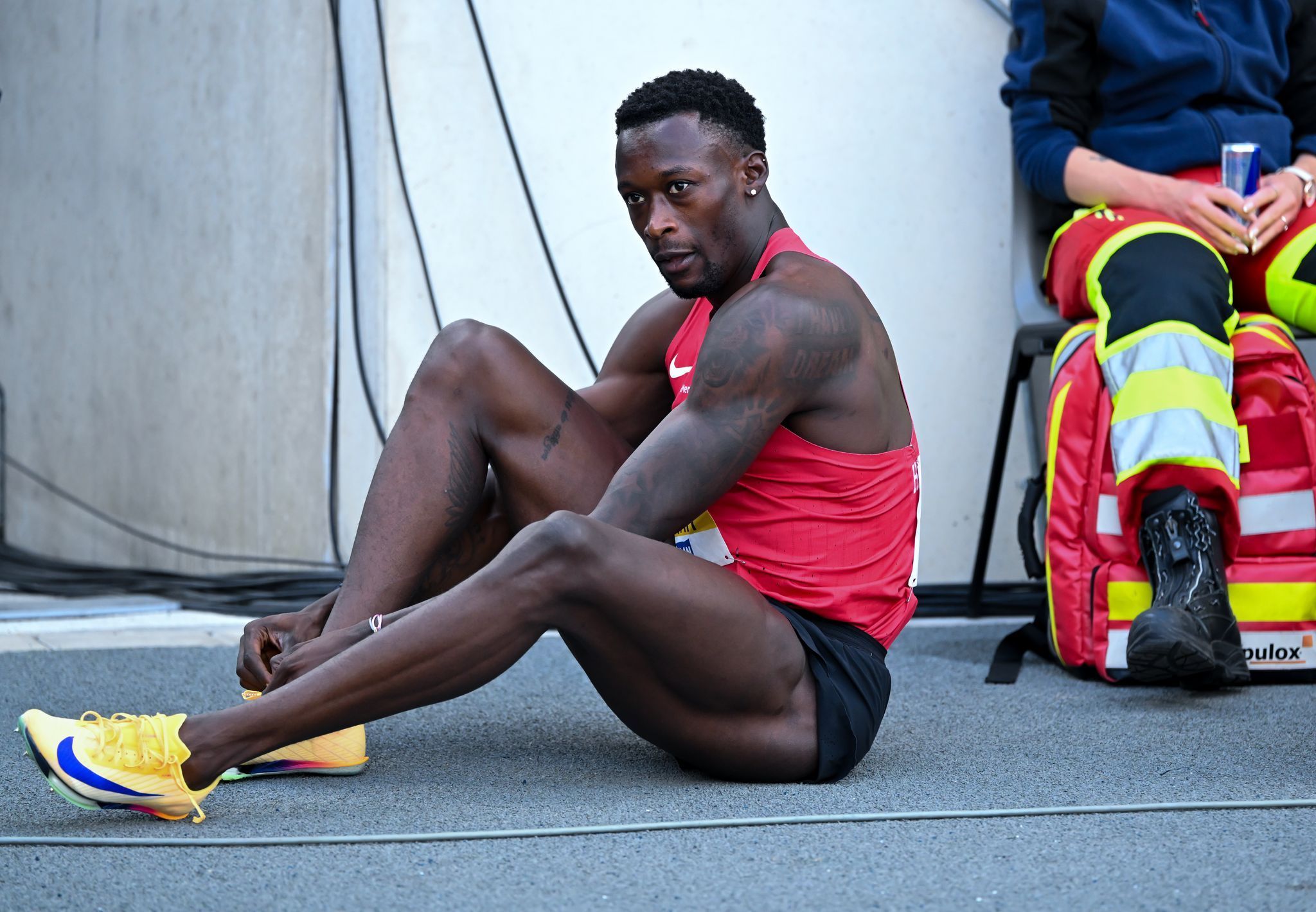 Owen Ansah bindet sich die Schuhe zu.