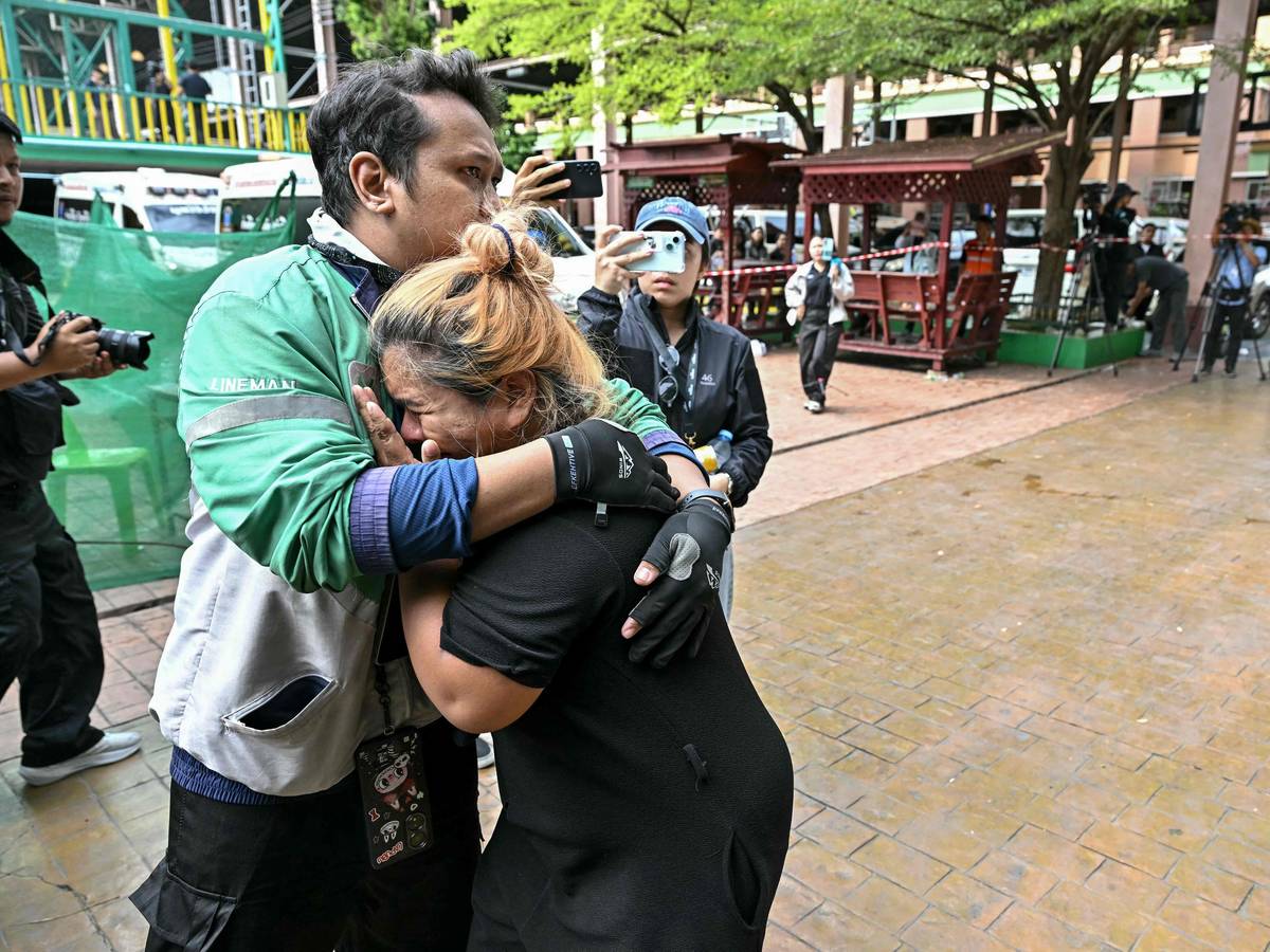 Angehörige eines Opfers des Schusswaffenvorfalls an der Schule trauern, während die Leichen der Verstorbenen in Krankenwagen gebracht werden. Die Aufnahme entstand am 7. August 2026 an der Schule im Bezirk Bang Kruai in der Provinz Nonthaburi nördlich der thailändischen Hauptstadt Bangkok.
