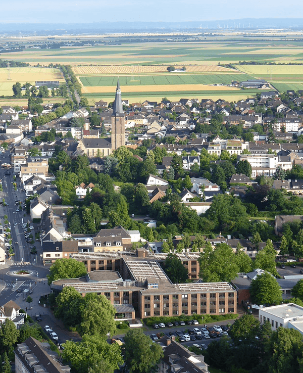 Luftbild einer Stadt mit Felder und Wiesen im Hintergrund