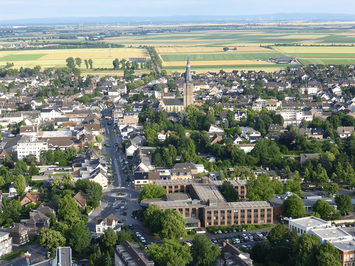 Luftbild einer Stadt mit Felder und Wiesen im Hintergrund