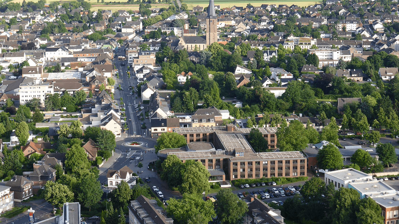 Luftbild einer Stadt mit Felder und Wiesen im Hintergrund
