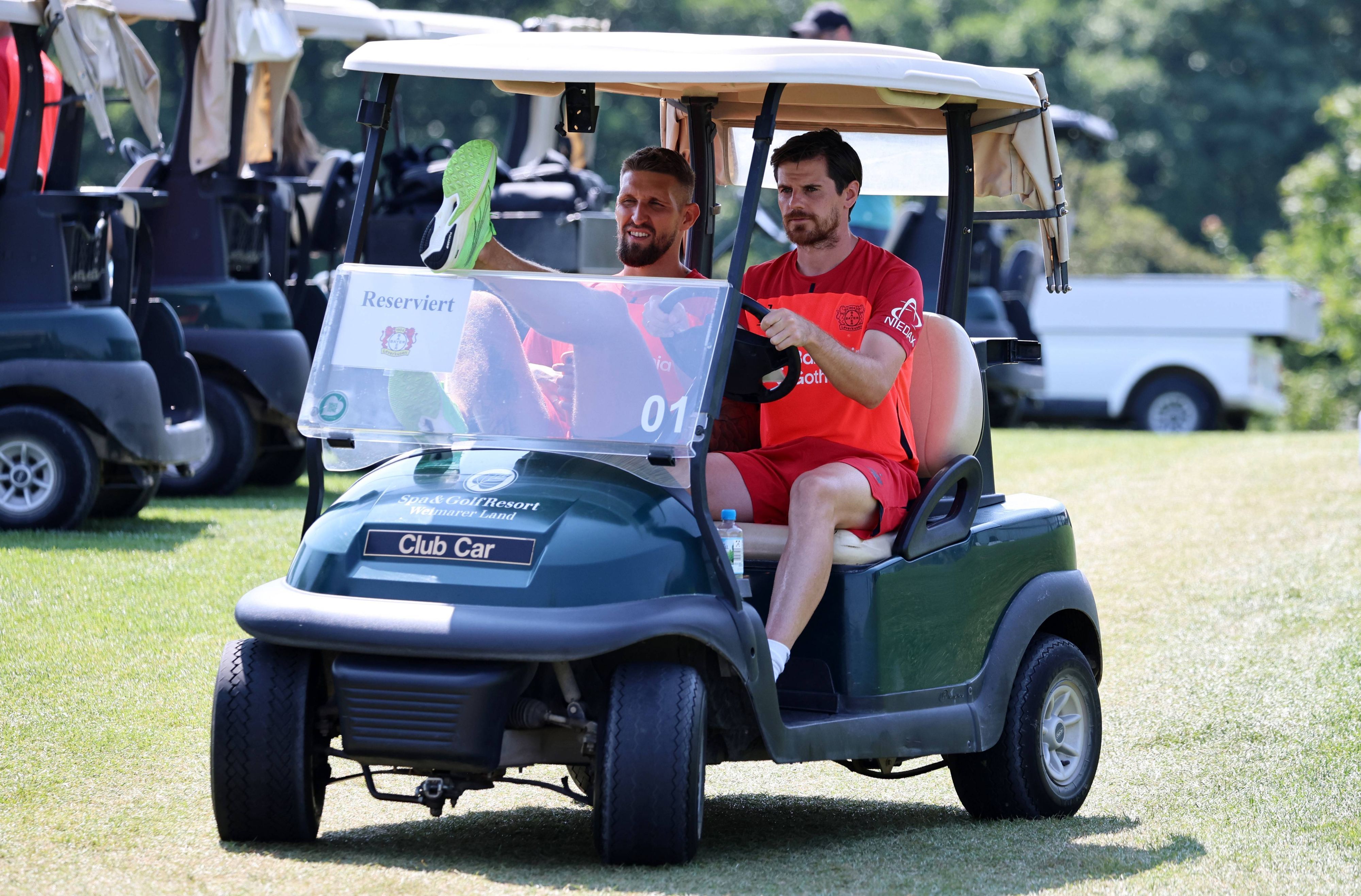 Robert Andrich und Jonas Hofmann fahren im Golf-Kart.
