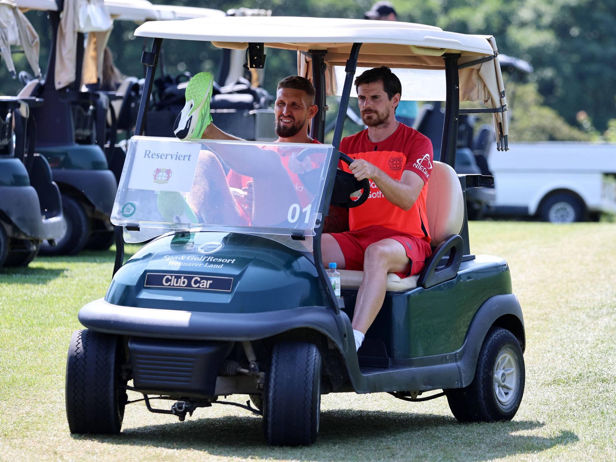 Robert Andrich und Jonas Hofmann fahren im Golf-Kart.