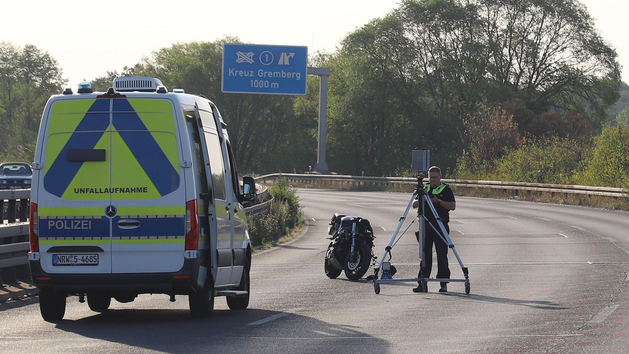 Ein Polizist nimmt Spuren mit einem Scanner auf. Bei einem Zusammenstoß zweier Motorräder auf der L124 in Köln sind zwei Männer ums Leben gekommen.