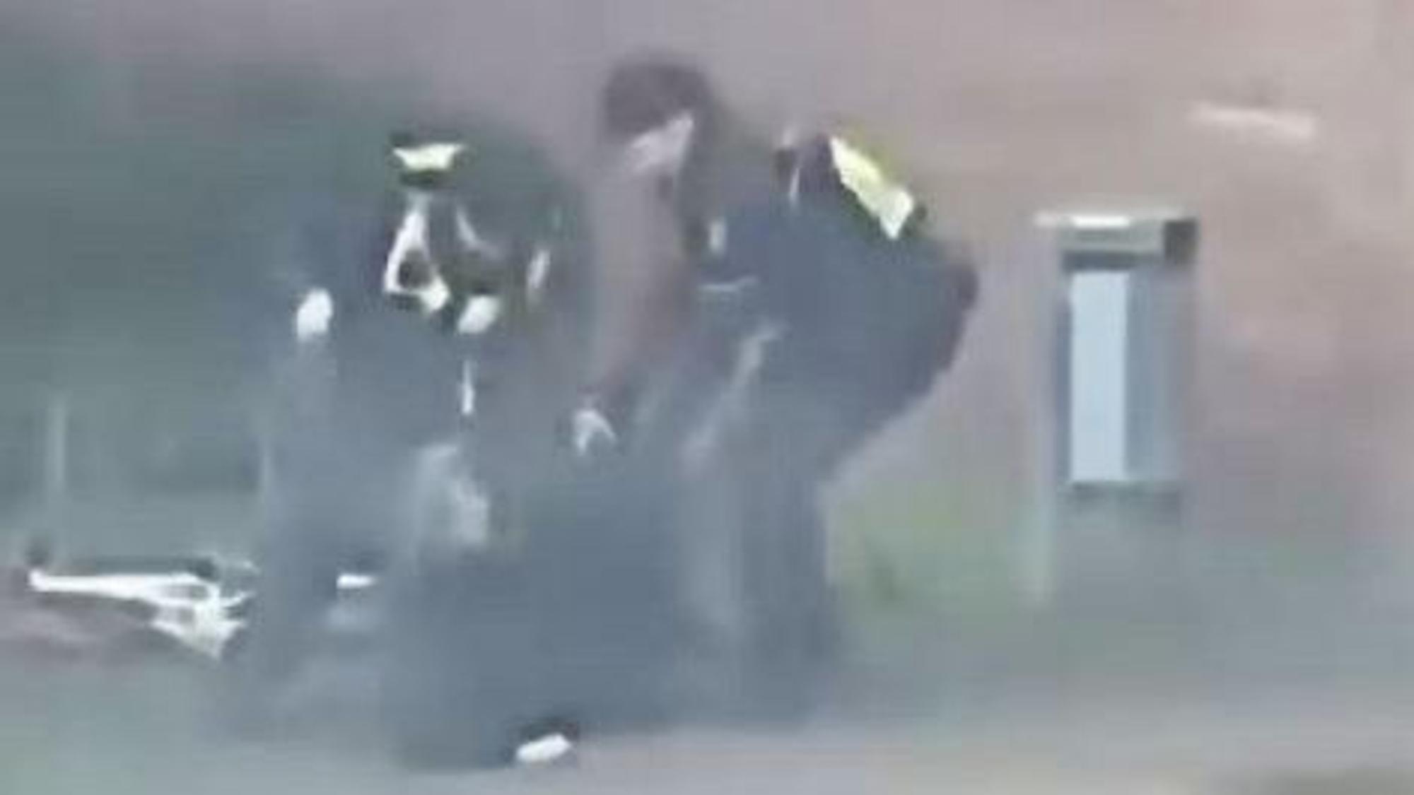 Das Bild zeigt eine Szene aus einem Video und zeigt zwei Polizisten, die auf einen Mann einprügeln.