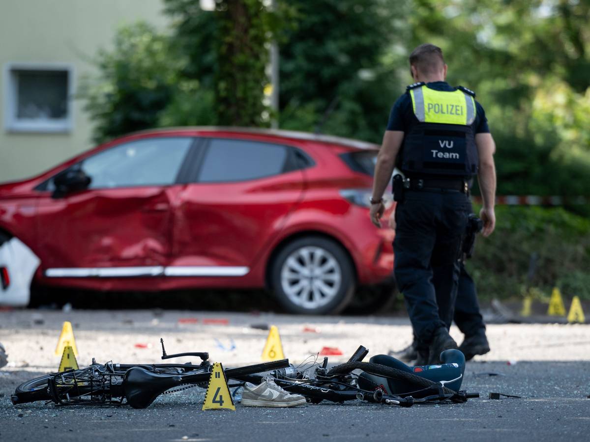 Ein Fahrrad liegt auf der Straße. Die Polizei sichert eine Unfallstelle.