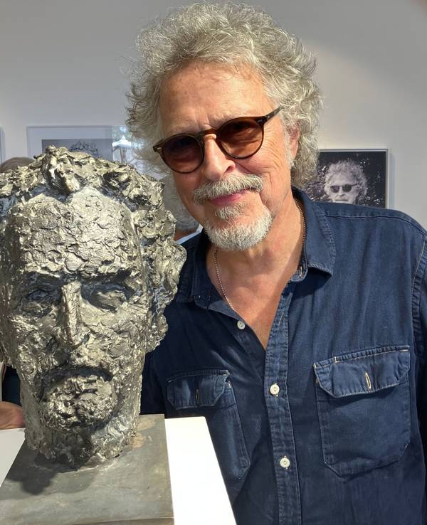 Wolfgang Niedecken steht bei der Eröffnung einer Vernissage neben seinem Bronze-Kopf.