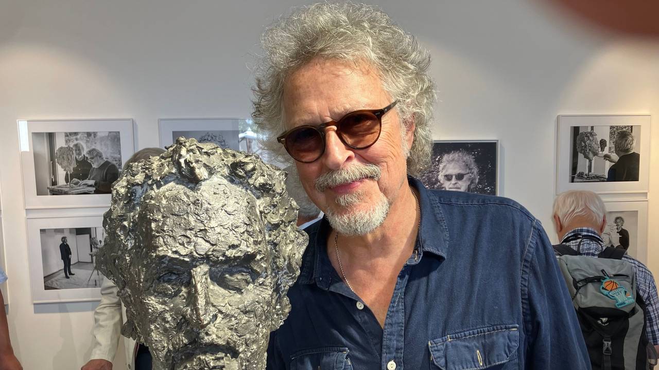 Wolfgang Niedecken steht bei der Eröffnung einer Vernissage neben seinem Bronze-Kopf.