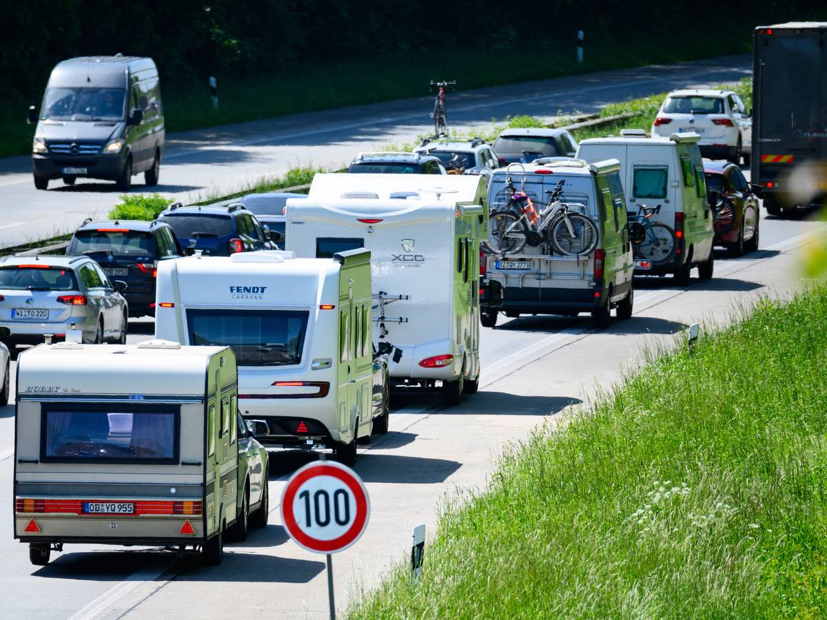 Zahlreiche Wohnmobile, Wohnwagen und Autos stehen im Autobahn-Stau.