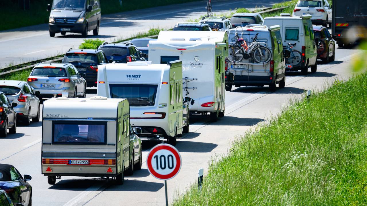 Zahlreiche Wohnmobile, Wohnwagen und Autos stehen im Autobahn-Stau.