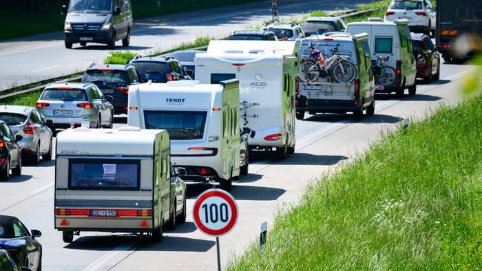 Zahlreiche Wohnmobile, Wohnwagen und Autos stehen im Autobahn-Stau.