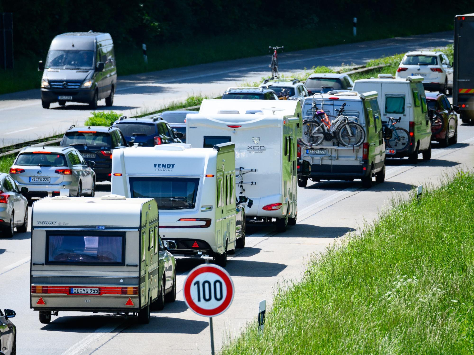 Zahlreiche Wohnmobile, Wohnwagen und Autos stehen im Autobahn-Stau.