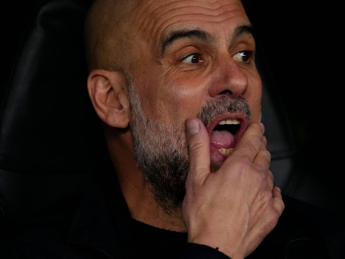 Pep Guardiola schaut auf das Spielfeld und streicht sich durch den Bart.