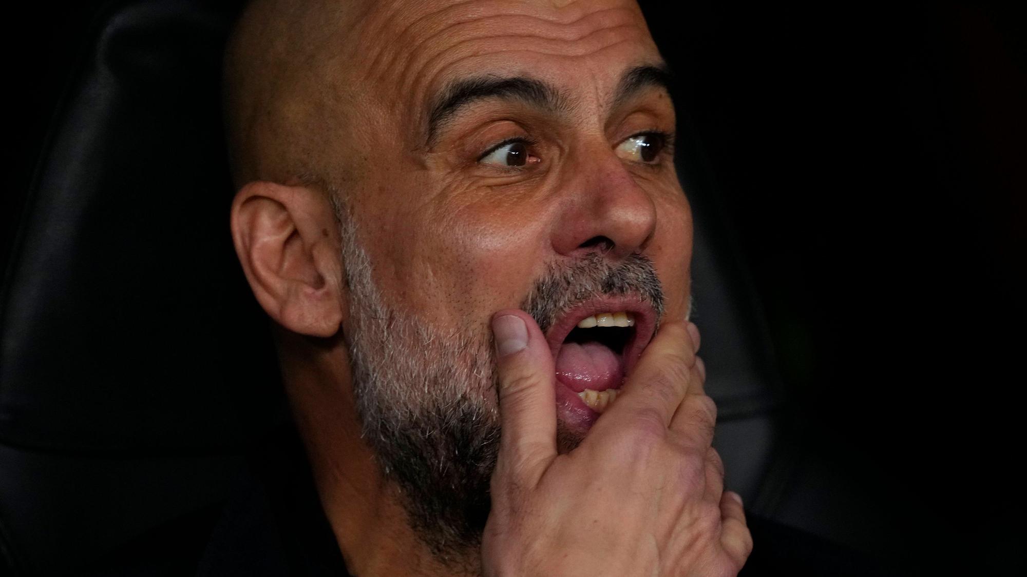 Pep Guardiola schaut auf das Spielfeld und streicht sich durch den Bart.