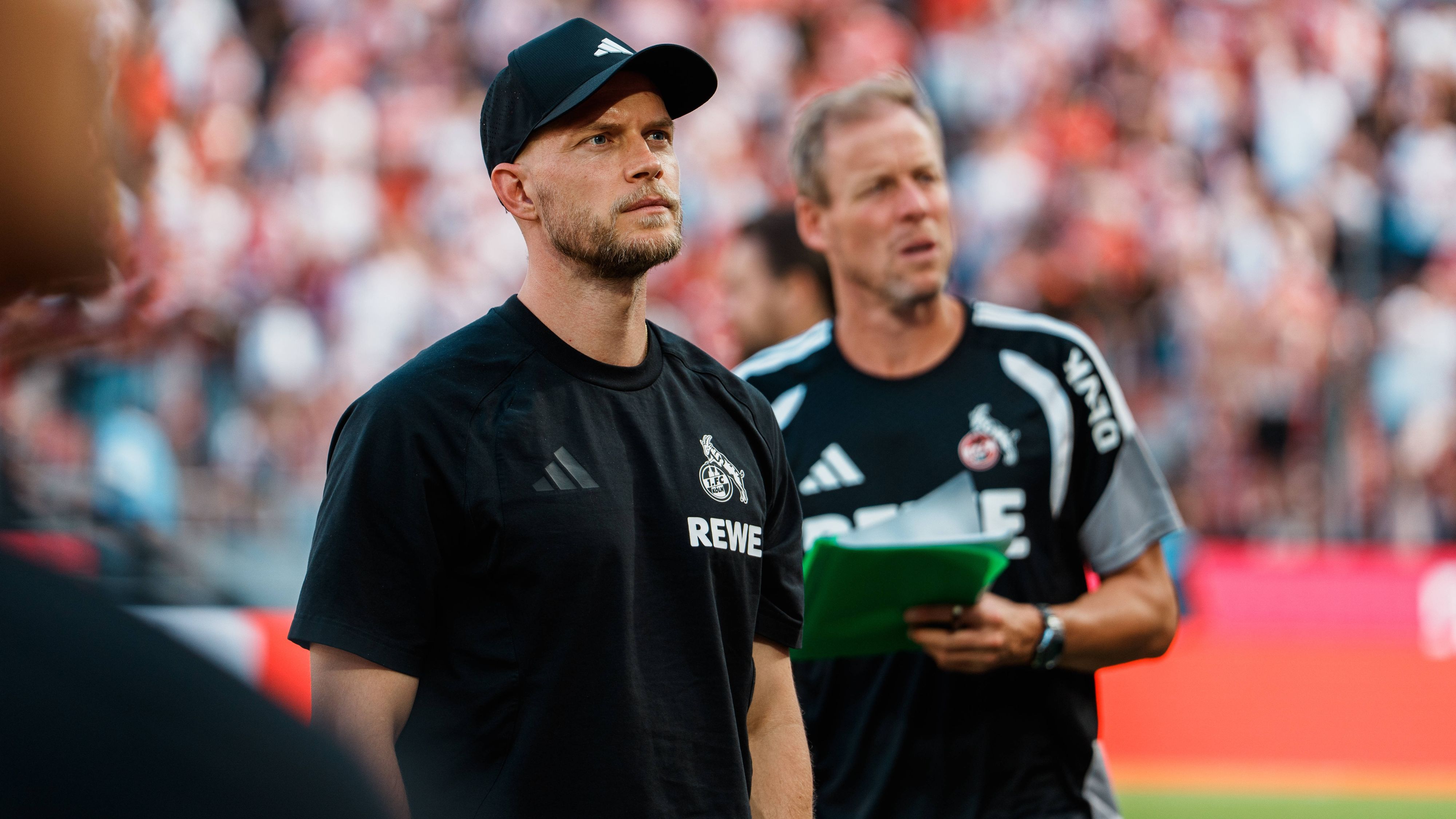 Beim Spiel des 1. FC Köln blickt sich René Wagner im Stadion um.
