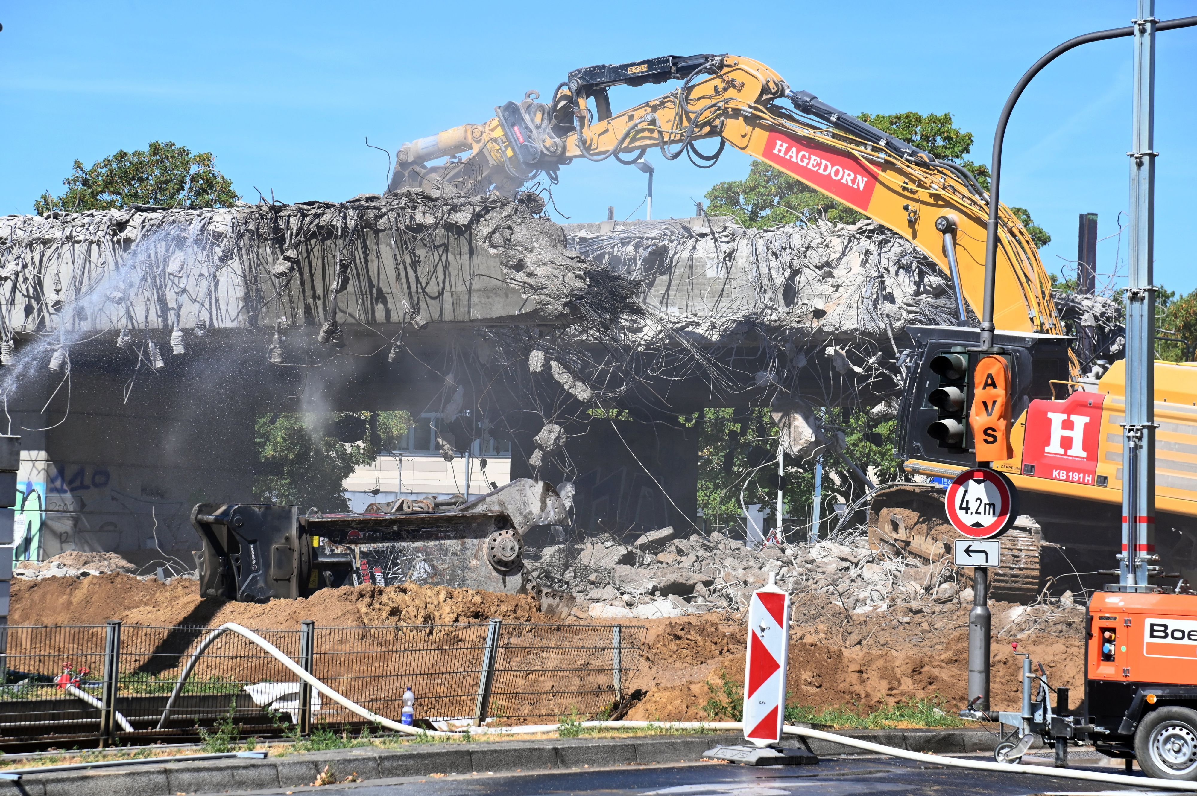Ein Bagger reißt ein Stück einer Brücke ab.