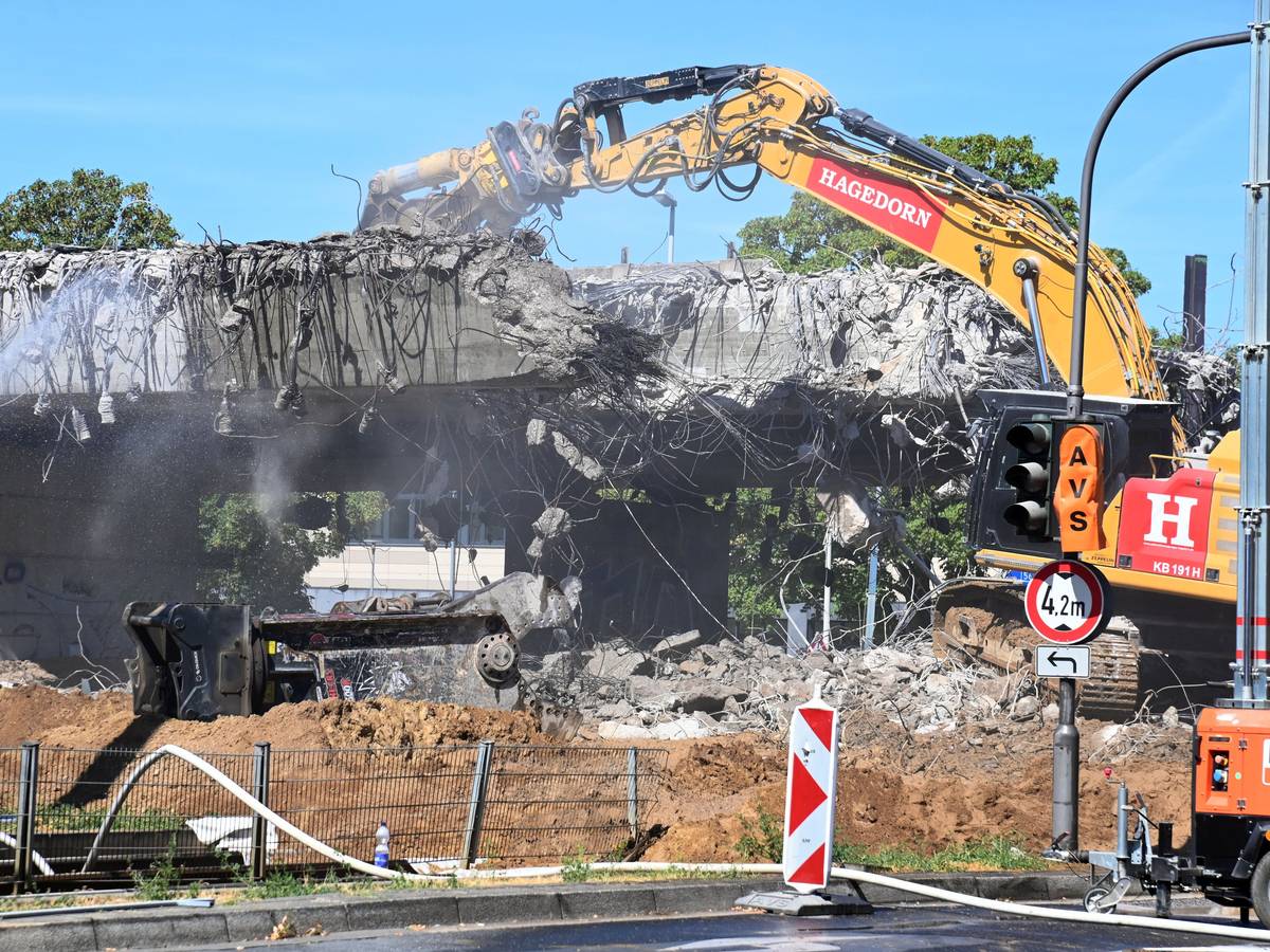 Ein Bagger reißt ein Stück einer Brücke ab.