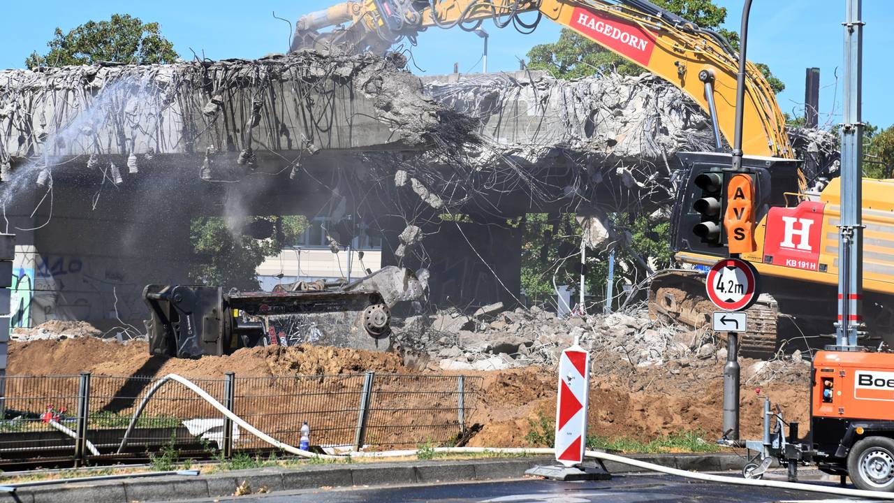 Ein Bagger reißt ein Stück einer Brücke ab.