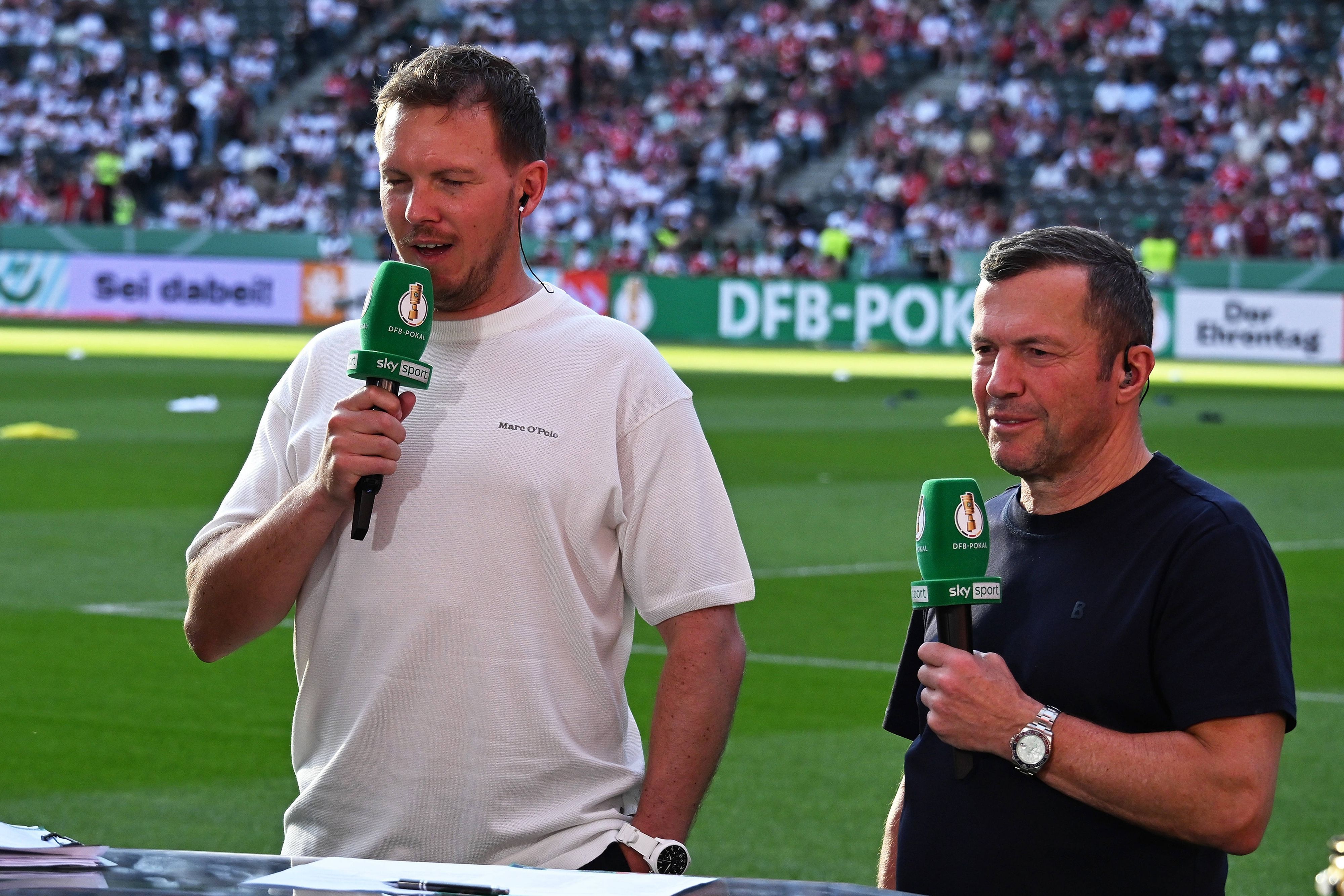 Lothar Matthäus steht neben Julian Nagelsmann. Beide haben Mikrofone in der Hand.