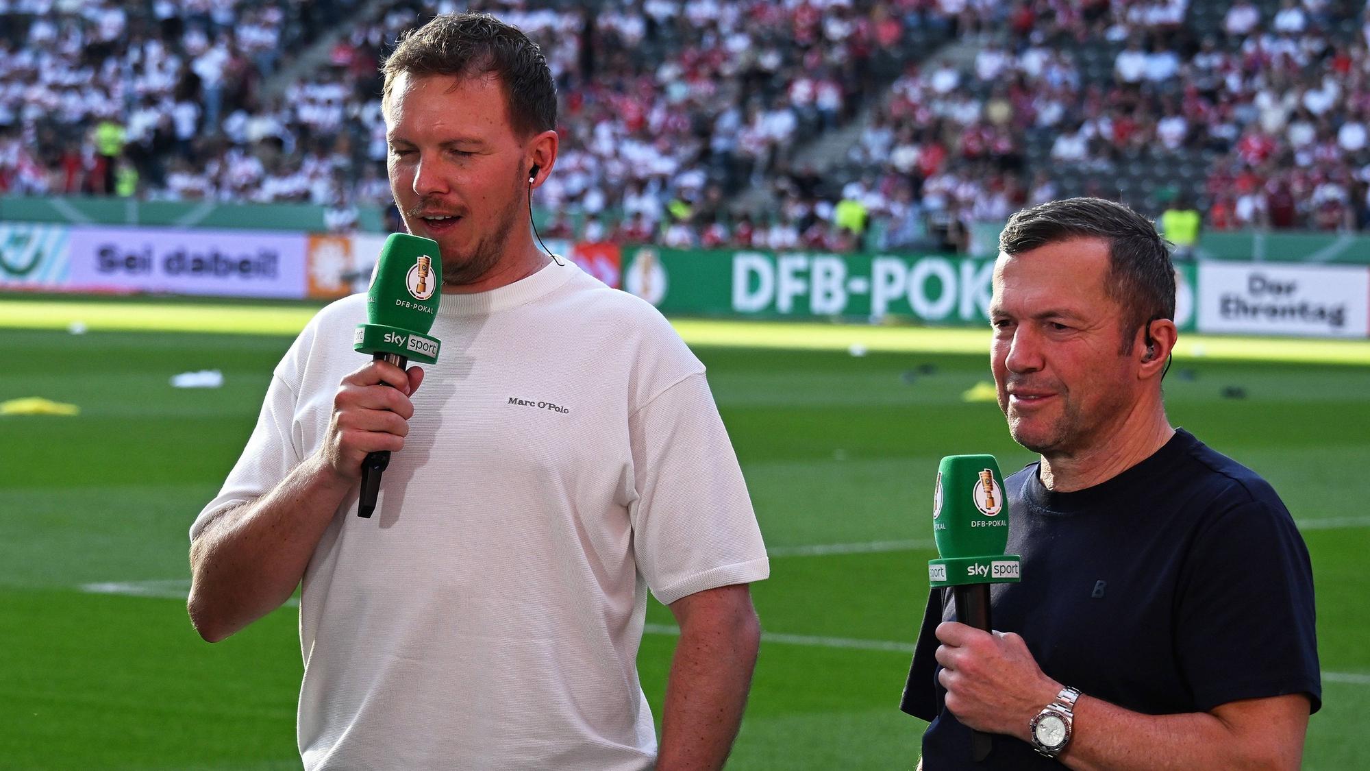 Lothar Matthäus steht neben Julian Nagelsmann. Beide haben Mikrofone in der Hand.