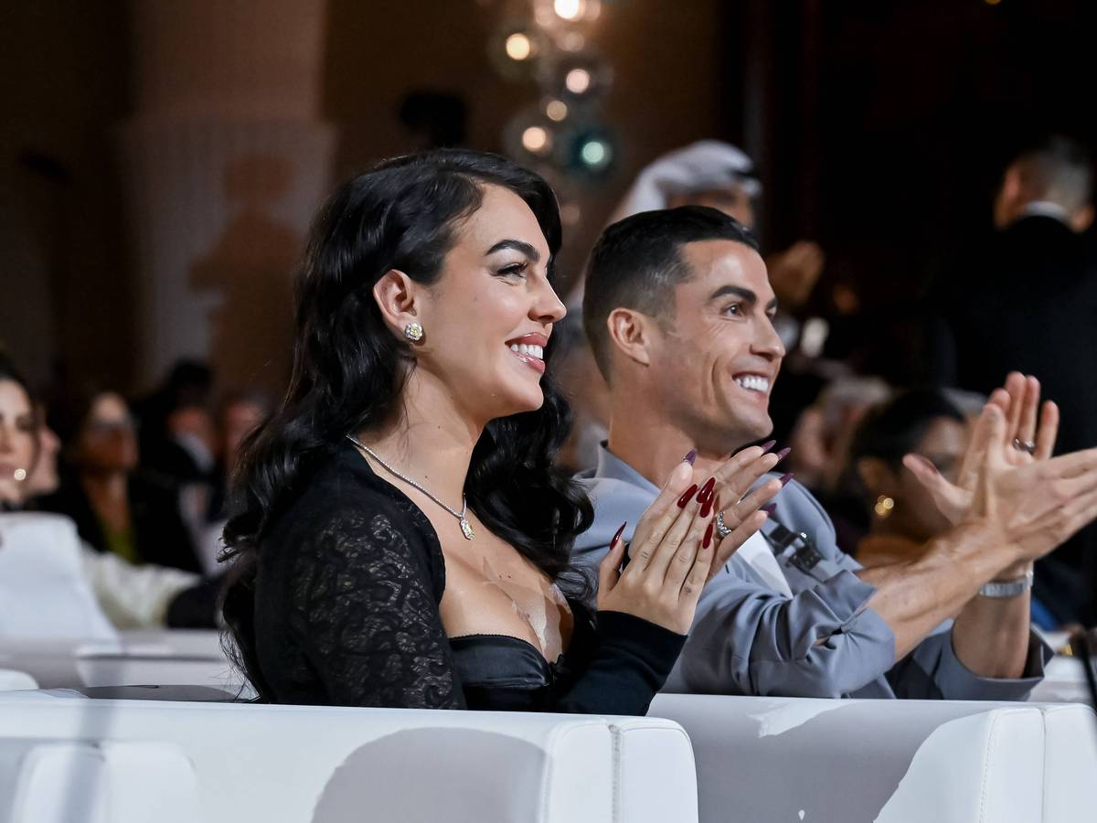 Georgina Rodríguez sitzt neben Cristiano Ronaldo und beide applaudieren.