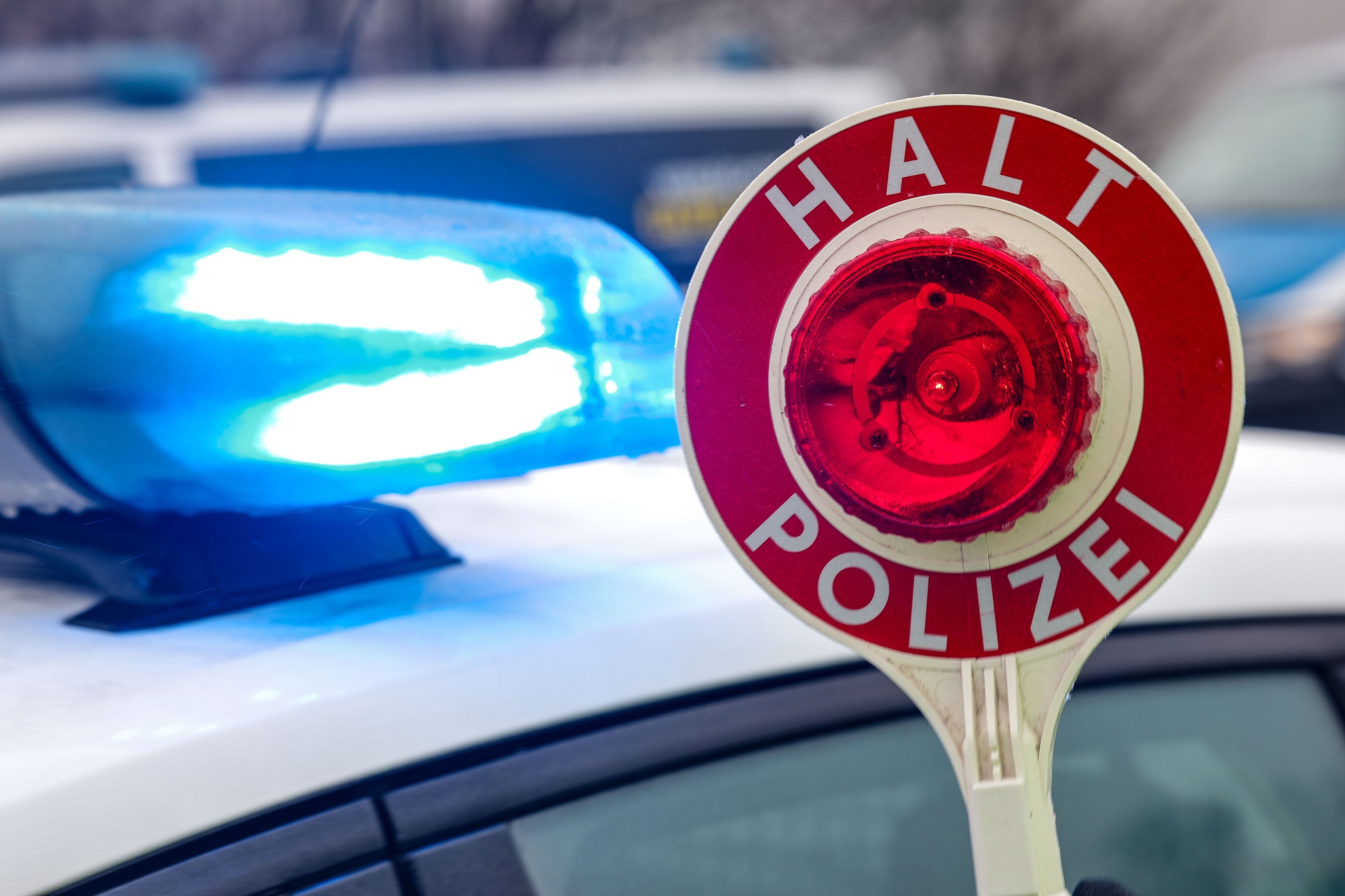 Ein Polizist hält eine Polizeikelle für eine Kontrolle. (Symbolfoto)