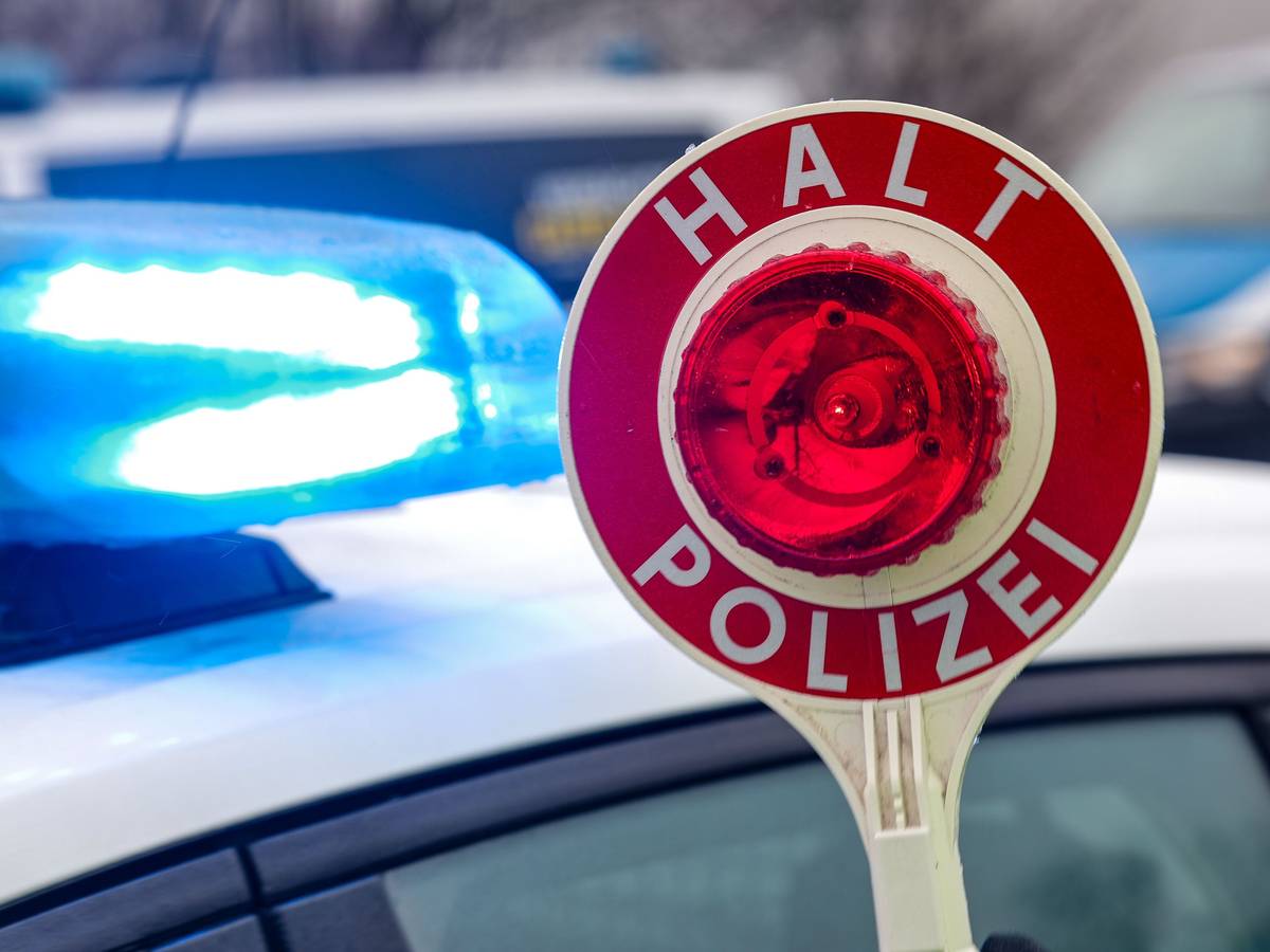 Ein Polizist hält eine Polizeikelle für eine Kontrolle. (Symbolfoto)