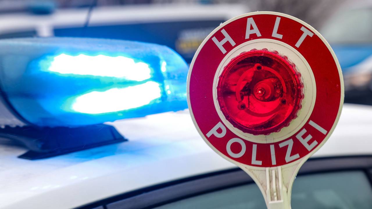 Ein Polizist hält eine Polizeikelle für eine Kontrolle. (Symbolfoto)