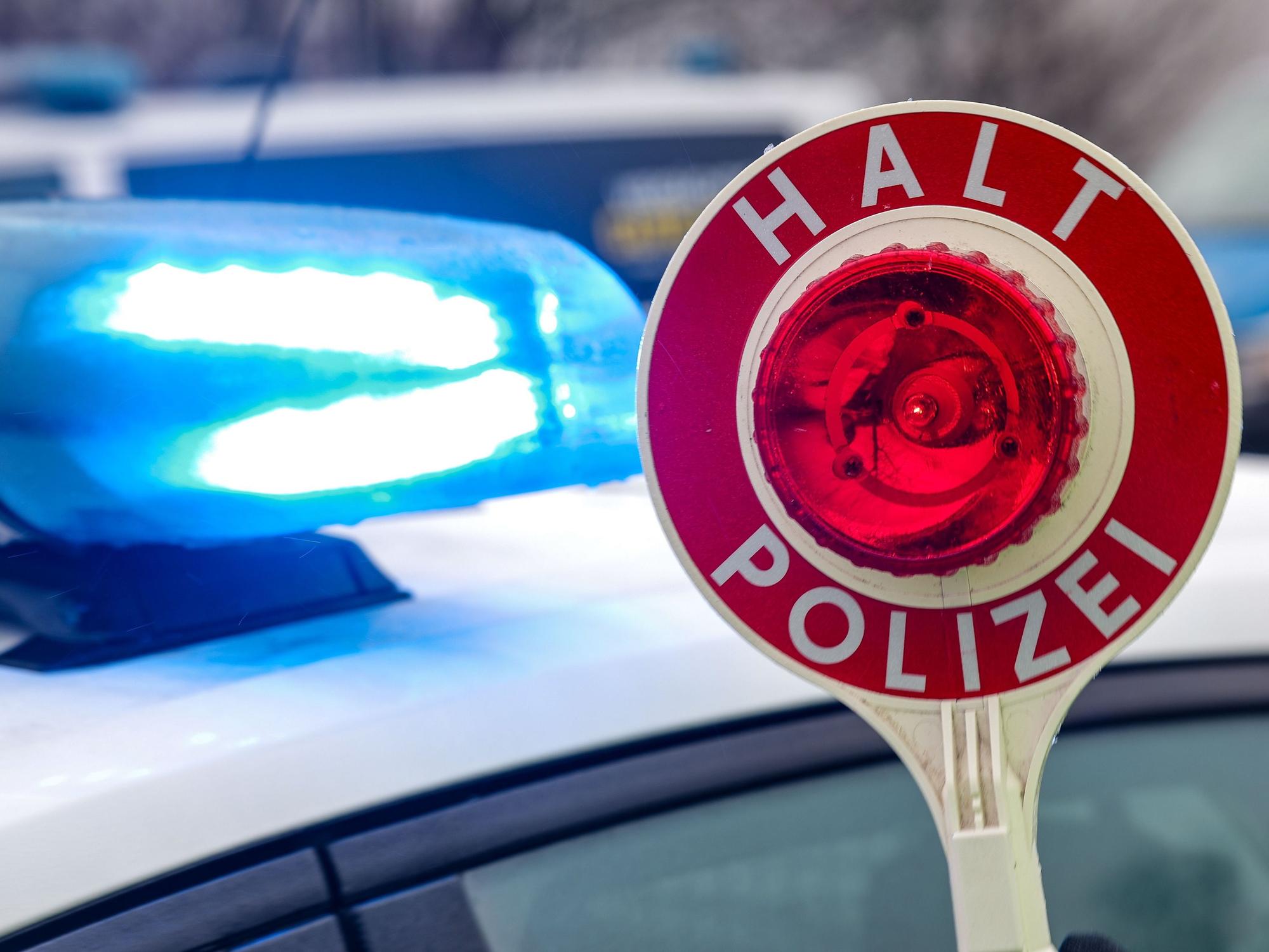 Ein Polizist hält eine Polizeikelle für eine Kontrolle. (Symbolfoto)