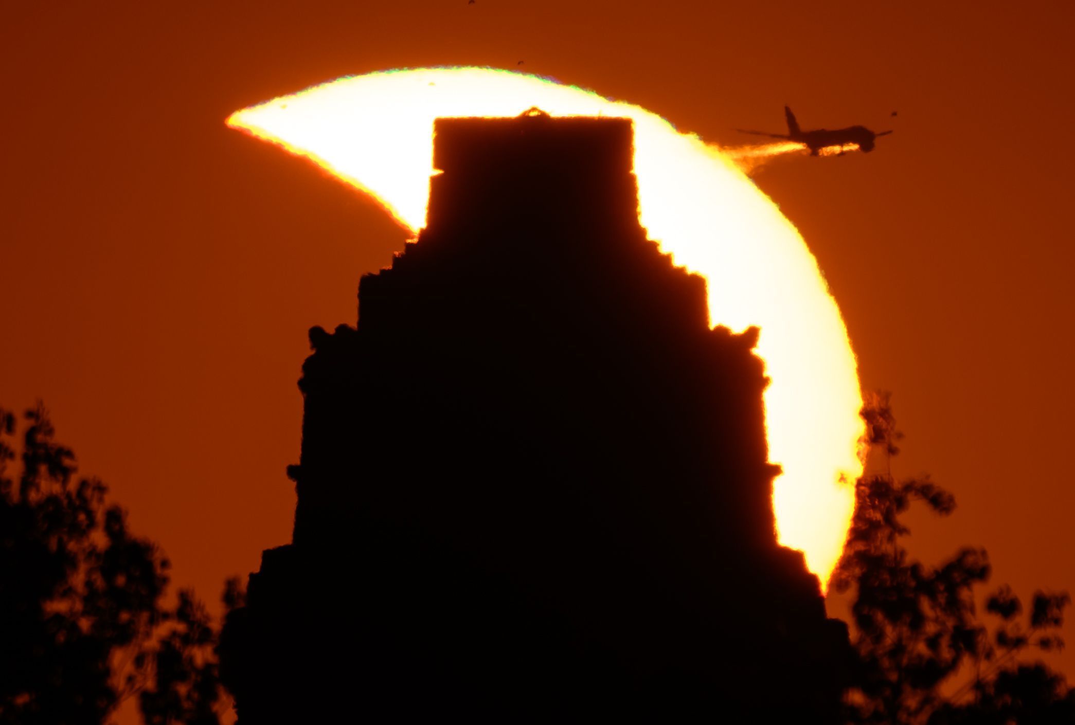 Leipzig: Die Spitze des Völkerschlachtdenkmals ragt vor der partiellen Sonnenfinsternis über den Horizont.