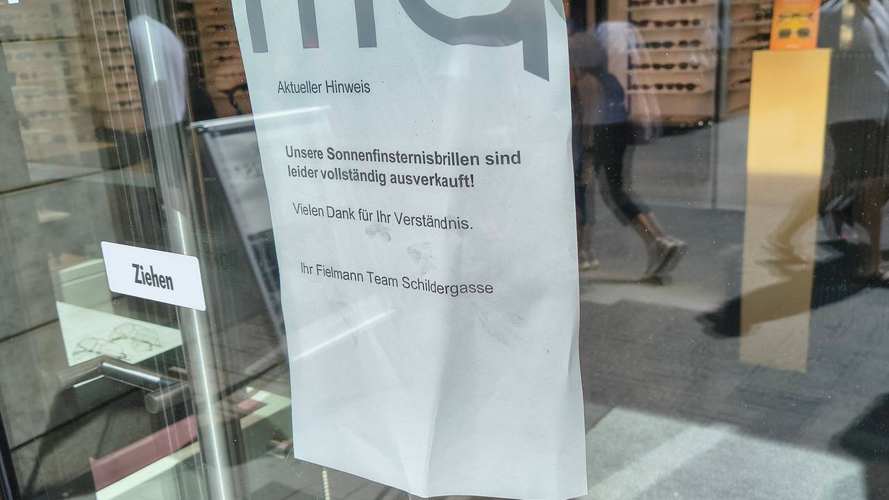 An der Tür eines Optikergeschäfts in der Kölner Innenstadt steht ein Schild mit der Aufschrift „Unsere Sonnenfinsternisbrillen sind leider vollständig ausverkauft!“.