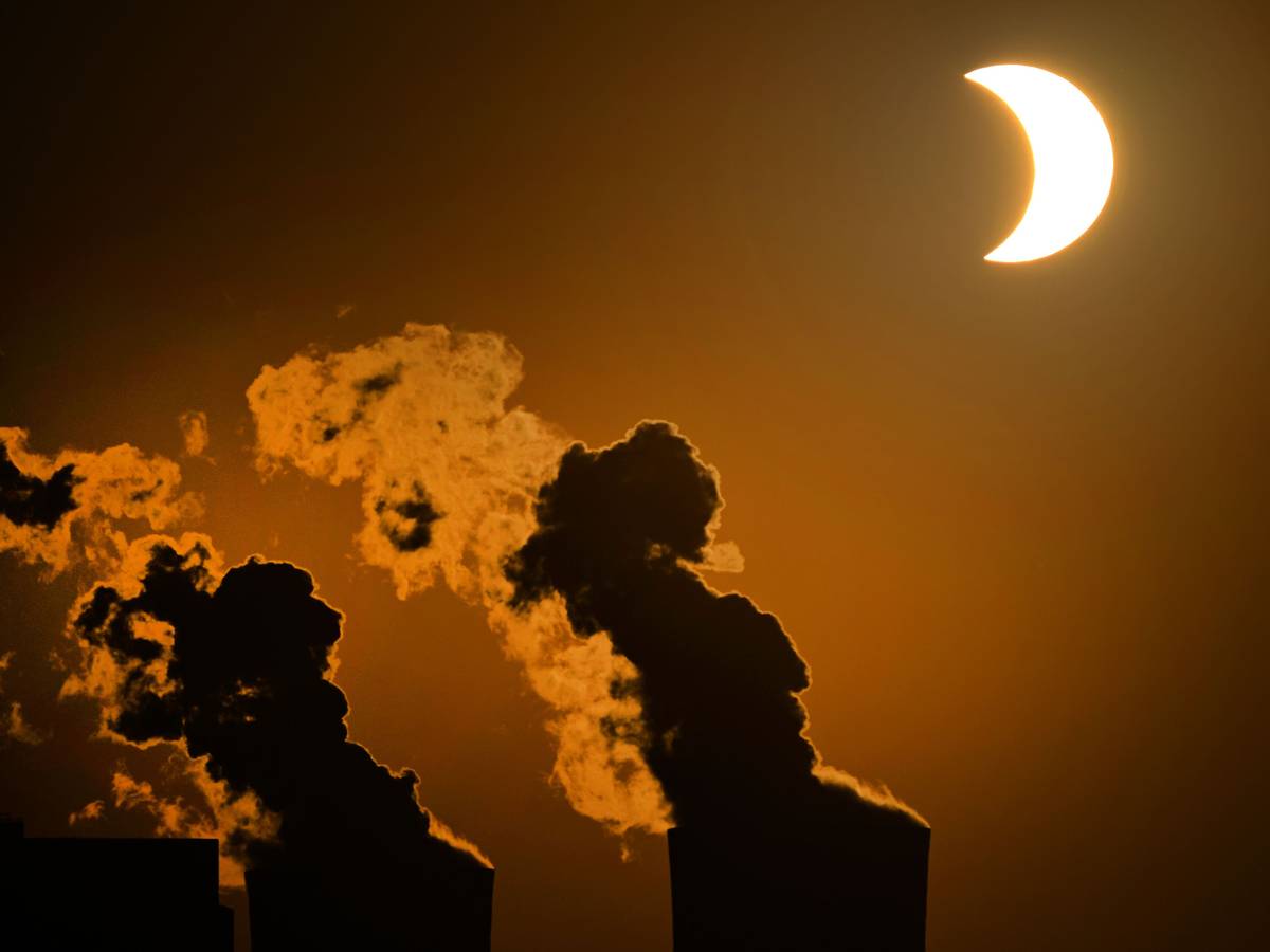 Die partielle Sonnenfinsternis ist am Himmel über dem Braunkohlekraftwerk Neurath in Pulheim bei Köln zu sehen.