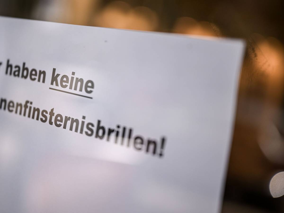 An der Tür eines Optikergeschäfts steht ein Schild mit der Aufschrift „Wir haben keine Sonnenfinsternisbrillen!“.