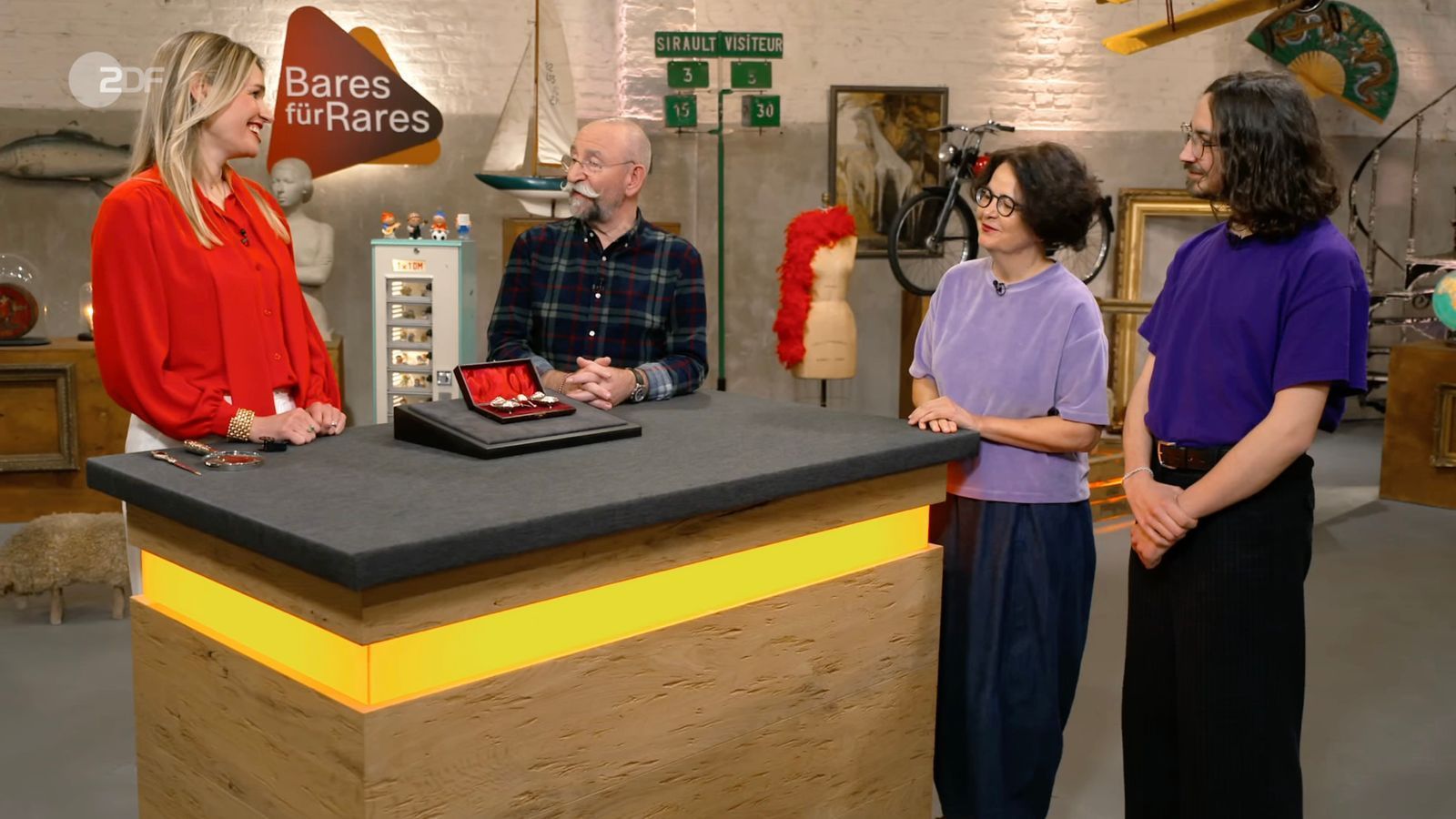 Verkäuferin Verena war mit Sohn Julian (rechts) zu „Bares für Rares“ angereist. Expertin Bianca Berding (links) und Moderator Horst Lichter konnten sich für ihr Objekt begeistern. (Bild: ZDF)